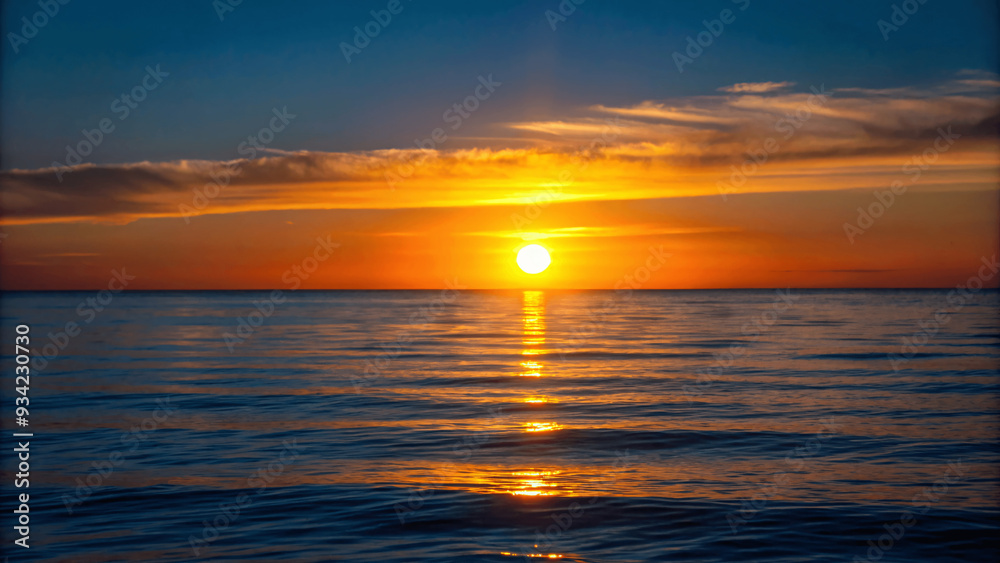A beautiful sunset over a calm ocean with the sun dipping below the Horizon A beautiful sunset over a calm ocean with the sun dipping below the Horizon