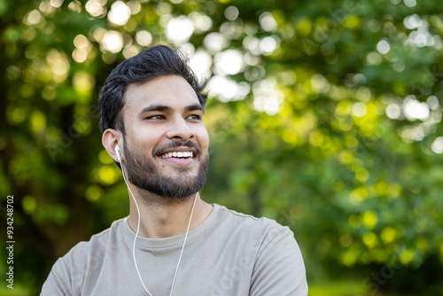 Canvas Print Close-up photo of a young smiling Indian man doing sports, standing in the park