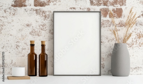 Minimalist decor featuring vases and a blank frame against a brick wall in na...