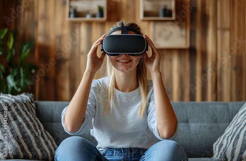 Young woman wearing virtual reality headset at home while sitting on a cozy sofa