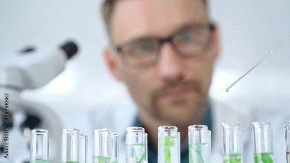 Man researcher with safety glasses is working with lab tubes using a pipette in laboratory, close-up of lab equipment. Science and medicine Man researcher with safety glasses is working with lab tubes using a pipette in laboratory, close-up of lab equipment. Science and medicine