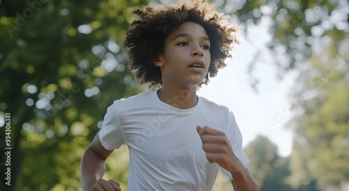 Un enfant / adolescent noir jouant et courant dans un parc en été, journée ensoleillée, sport, santé mentale, vie saine, exercice physique, jogging photo