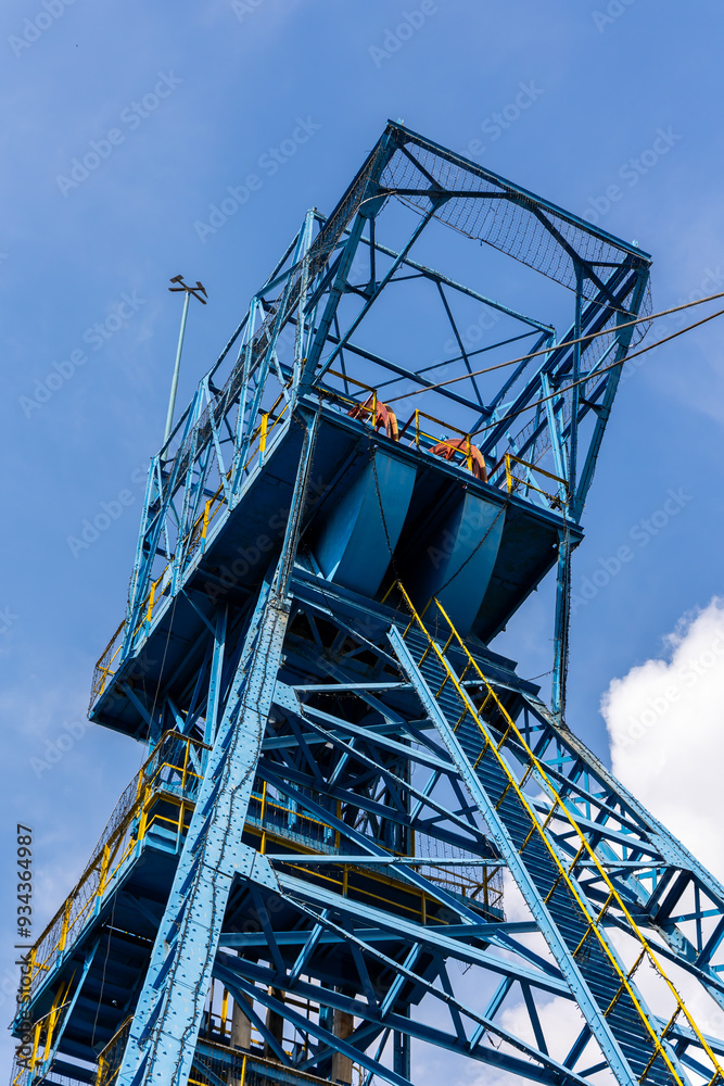 Blue coal mine shaft against a blue sky with delicate clouds. Reduction of fossil fuel extraction in favor of renewable fuels