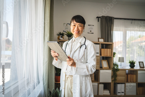 Portrait of mature japanese woman doctor stand with digital tablet photo