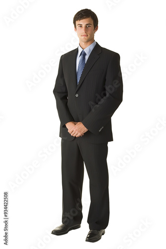 Confident young businessman in a dark suit and blue tie stands with hands clasped, portraying professionalism against a white background.