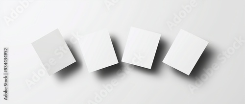 Four blank white sheets arranged in a tilted line on a light background with shadows, ideal for stationery mockups, presentations, and design concepts.

