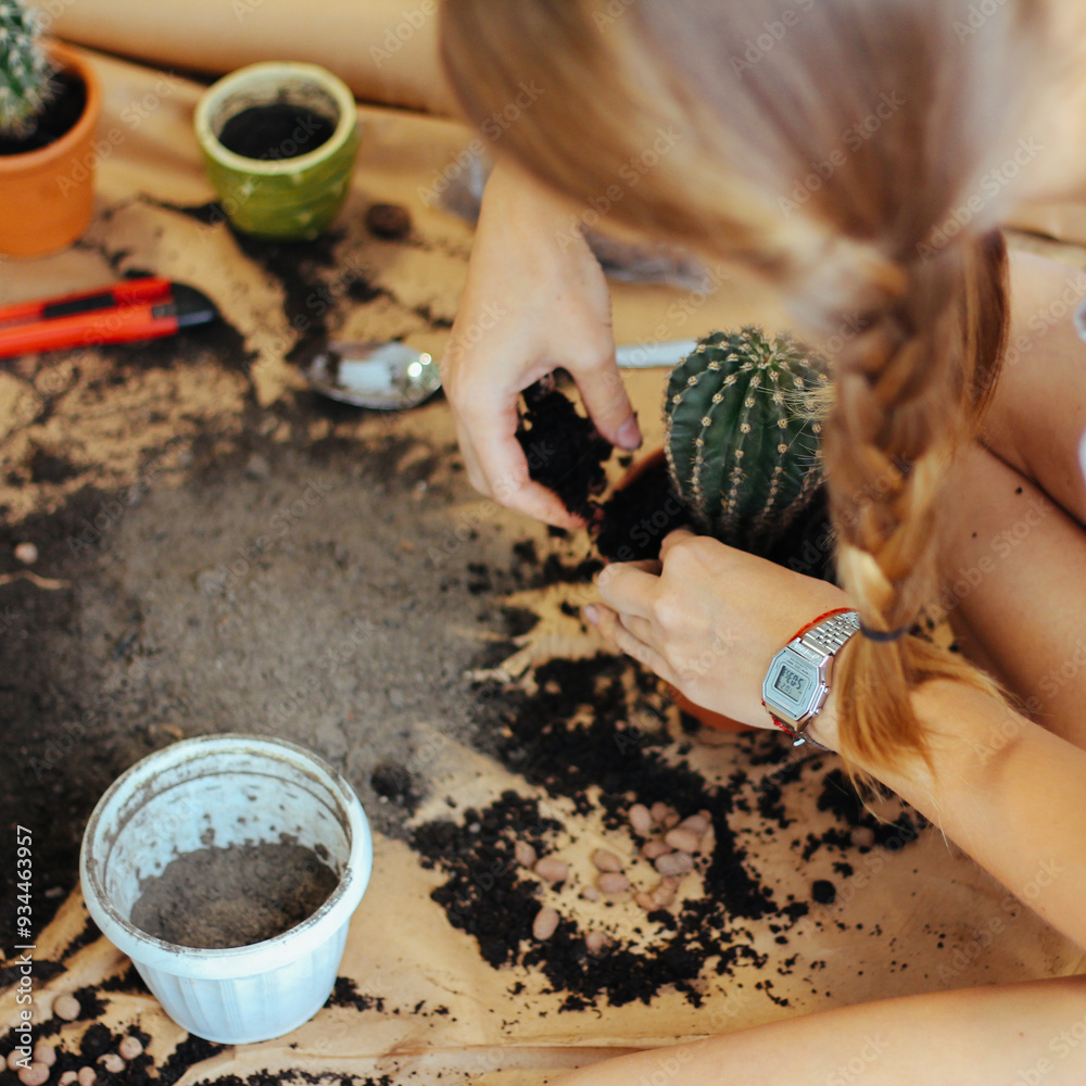 Close-up of hands planting a cactus, surrounded by soil and garden tools, promoting the simplicity and joy of home gardening.