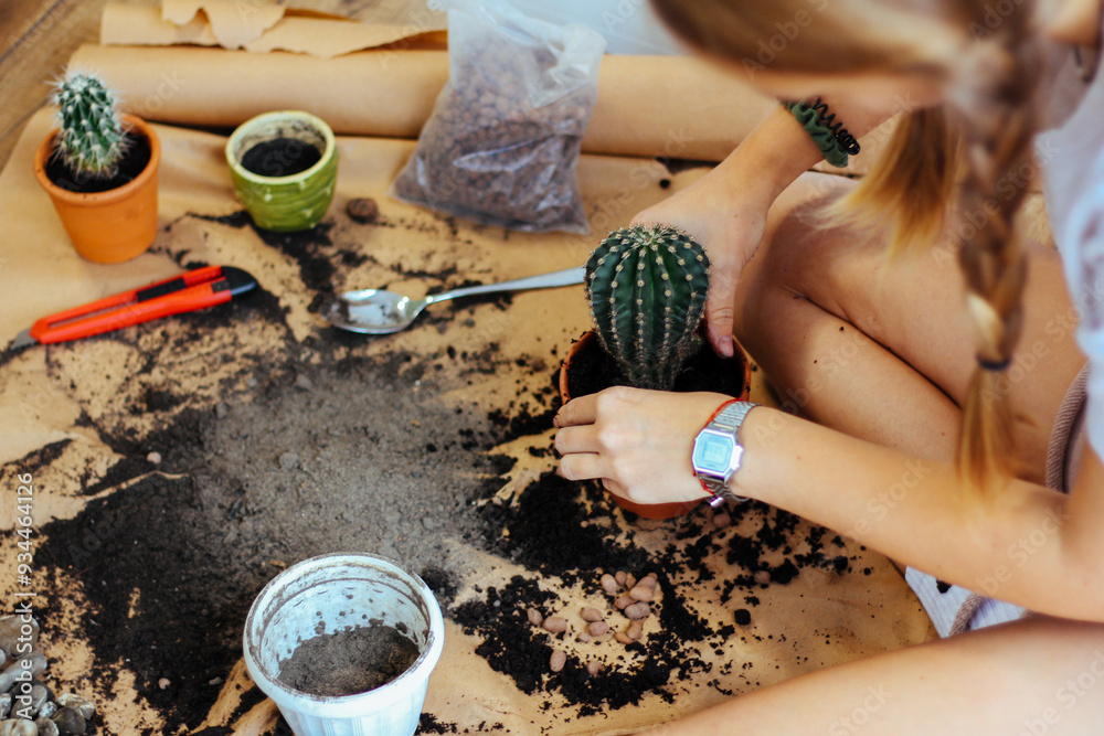Close-up of hands planting a cactus, surrounded by soil and garden tools, promoting the simplicity and joy of home gardening.
