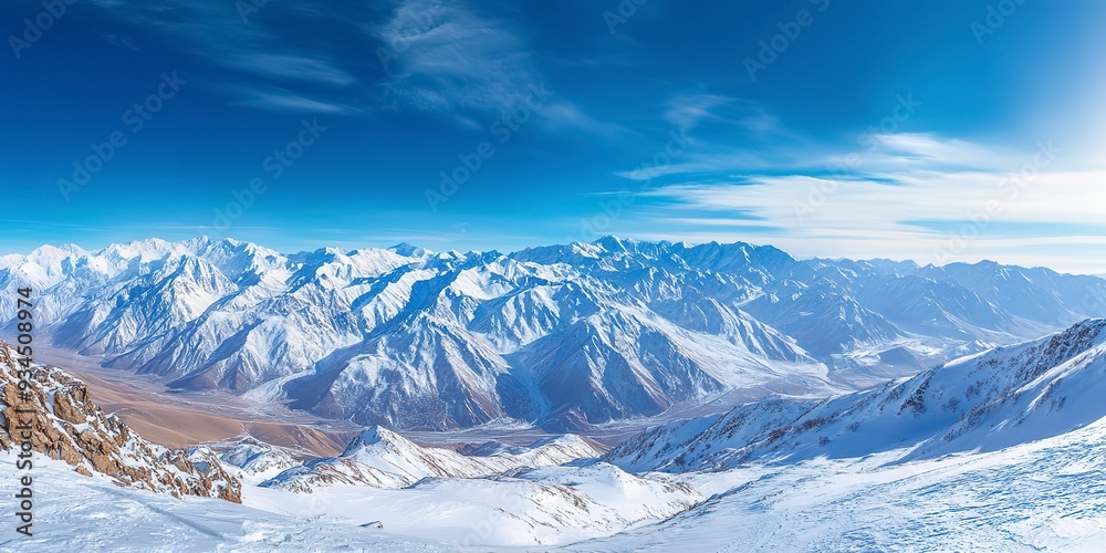 Fototapeta premium Wide angle view landscape of white snowy mountains range with clear blue sky during cold winter. Nature concept for extreme lifestyle product background