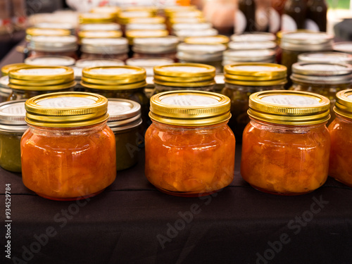 Peach preserves in small glass jars for sale at a local farmer's market; copy space