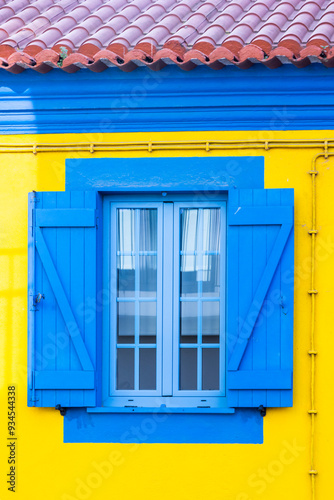 Portugal, Aveiro. Brightly colored blue window on a yellow building.