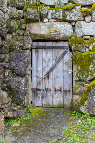 Portugal, Soajo. A wooden door in an old stone wall. photo