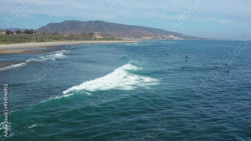 Ascending in reverse above Trestles' waves with surfers and San Onofre beyond