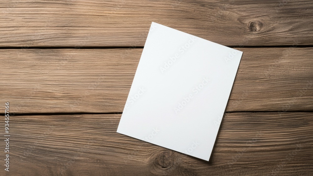 A white piece of paper is sitting on a wooden table A white piece of paper is sitting on a wooden table