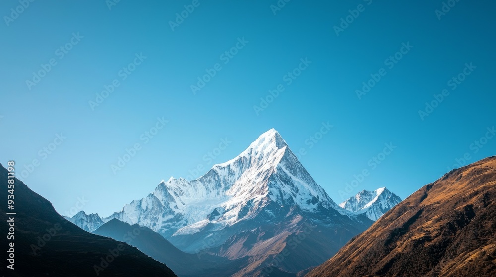 Fototapeta premium Majestic mountain range with snow-capped peaks and clear blue sky above. Majestic Mountain Range