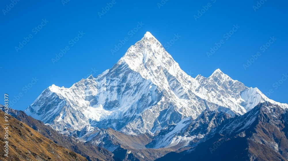 Obraz premium Majestic mountain range with snow-capped peaks and clear blue sky above. Majestic Mountain Range