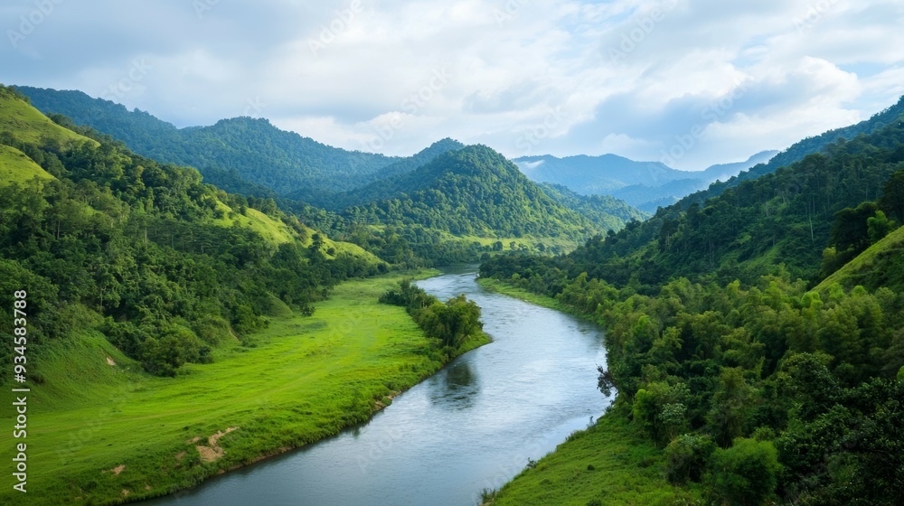 Fototapeta premium A peaceful valley surrounded by lush green mountains and gentle river flowing through it. Serene Mountain Valley