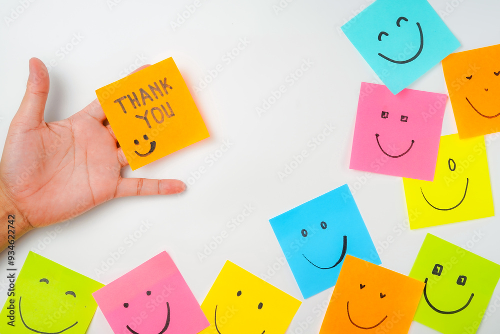 Thank you and smile icon inspirational handwriting on sticky notes on hand held Thank you and smile icon inspirational handwriting on sticky notes on hand held
