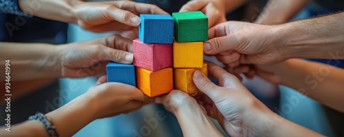 Hands of diverse people stacking blocks to build a tower, representing teamwork and cooperation photo