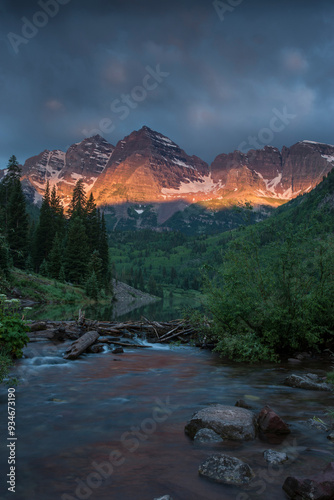 USA, Colorado, Maroon Bells State Park. Summer sunrise storm clouds on Maroon Bells mountains.  photo
