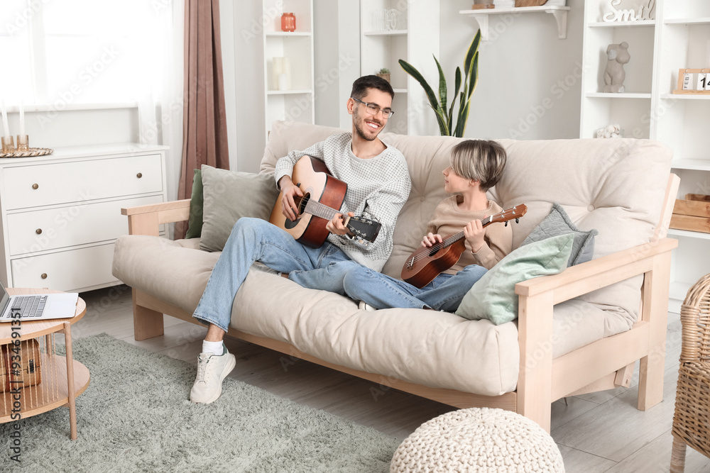 Private music teacher giving guitar lessons to little boy in living room Private music teacher giving guitar lessons to little boy in living room