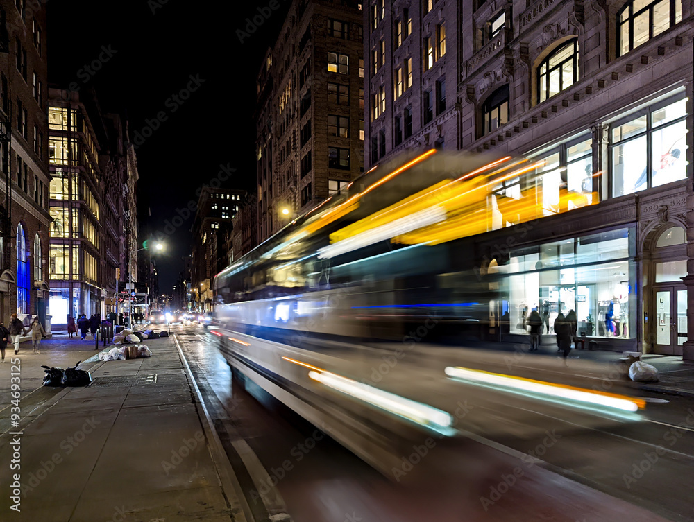 Bus headlights streaking down the street with motion blur effect at night in New York City