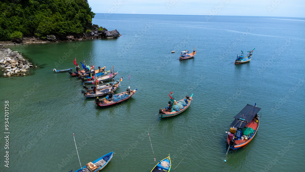 Obraz premium Aerial drone view of traditional colorful thai old wooden fishing boats on shore during low tide. Traditional Thai long-tailed fishing boats in tropical sea