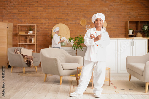 Smiling young girl chef hol...