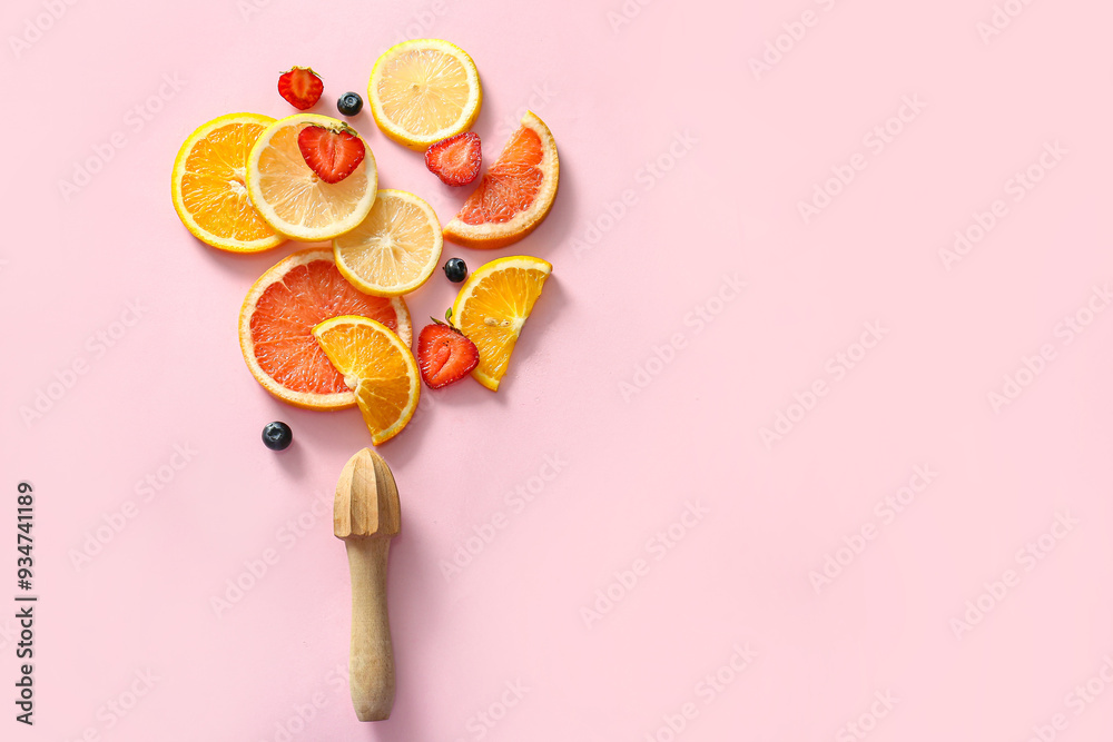 Sliced citrus fruits, berries and juicer on pink background Sliced citrus fruits, berries and juicer on pink background