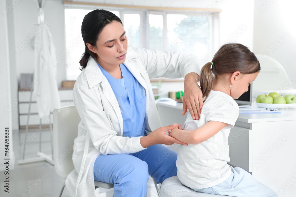Obraz premium Female osteopath working with little patient in clinic