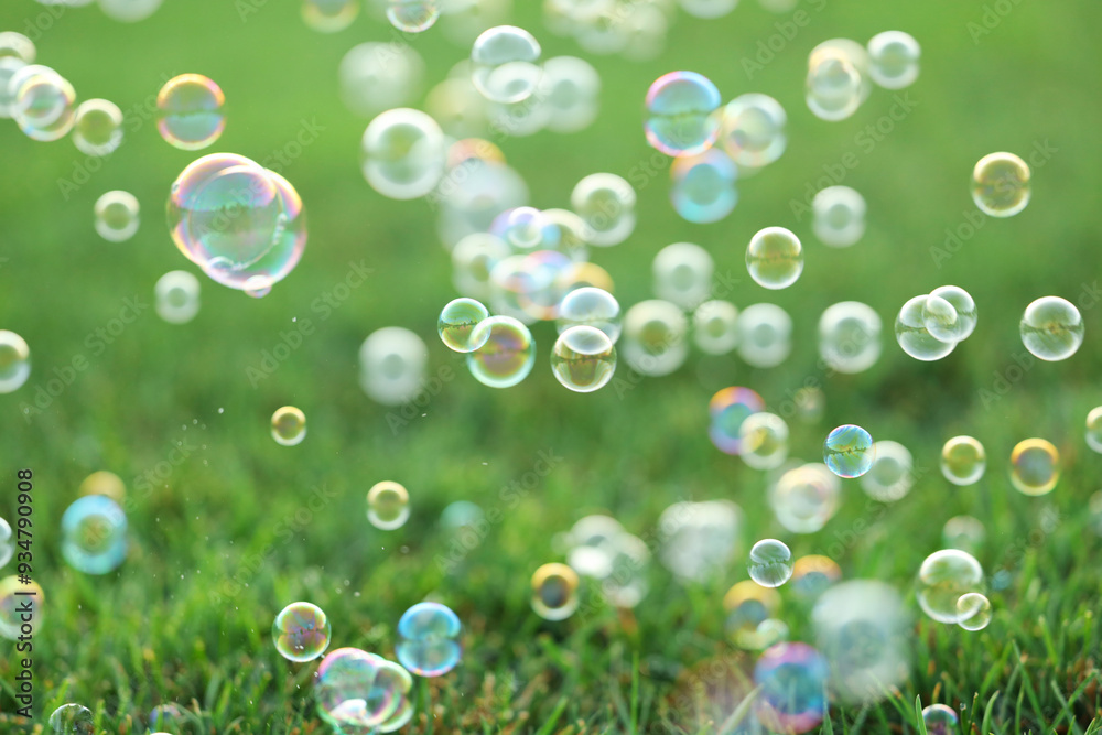 Many beautiful soap bubbles floating above green grass Many beautiful soap bubbles floating above green grass