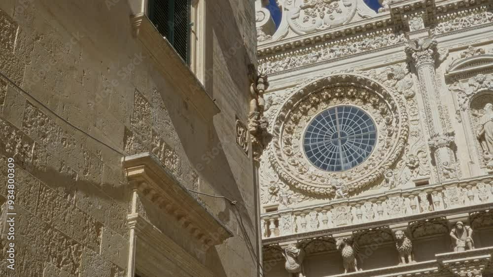 Intricate facade of a historic baroque church in lecce, puglia, italy, featuring detailed stone carvings and a large circular stained-glass window under a clear blue sky. Intricate facade of a historic baroque church in lecce, puglia, italy, featuring detailed stone carvings and a large circular stained-glass window under a clear blue sky.