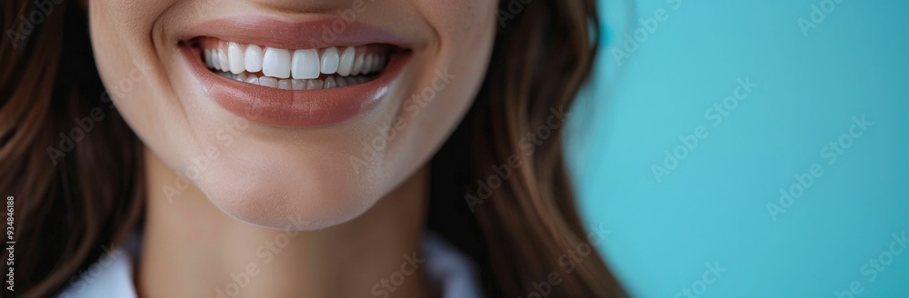 Fototapeta premium A close up portrait of a smiling woman with perfect teeth against a vibrant blue background conveying beauty and confidence