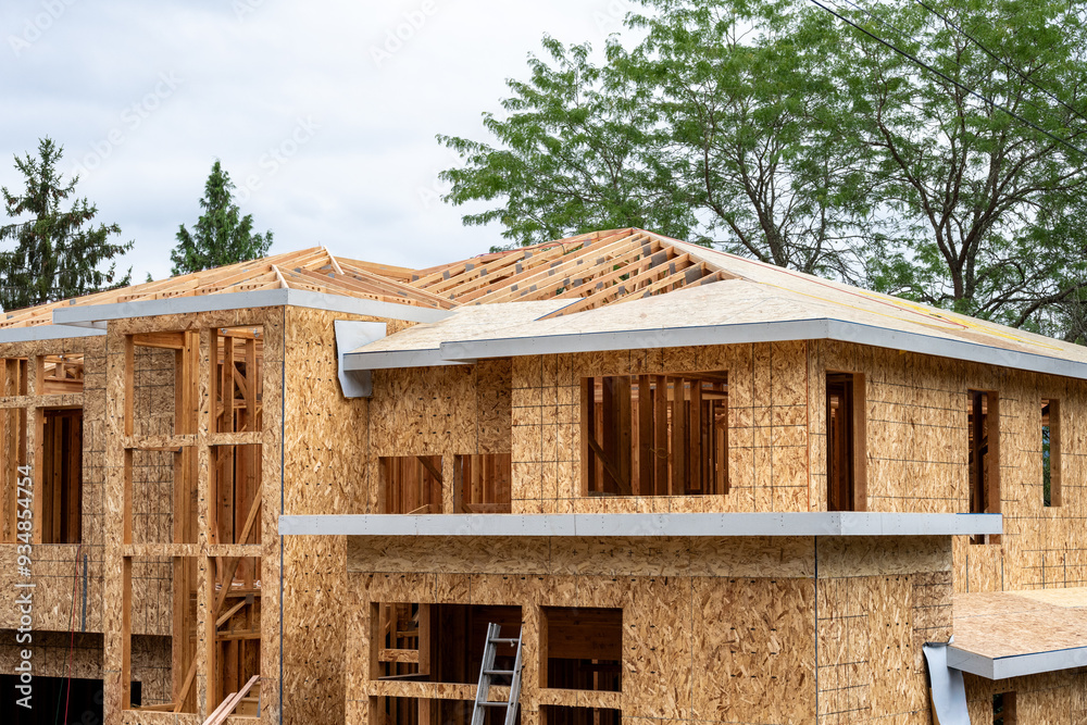 New large residential home construction in framing stage, with exterior ...