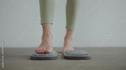 Two young attractive women in house are addicted to yoga and meditation on floor. With bare feet, girls stand on sadhu board with nails. concentration and inner energy. taking care of body