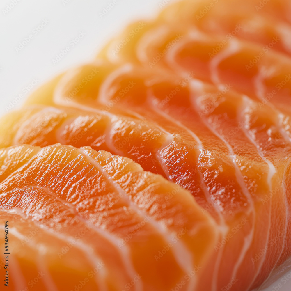 A close up of a piece of salmon with its skin still on. The salmon is sliced into thin strips and has a golden color A close up of a piece of salmon with its skin still on. The salmon is sliced into thin strips and has a golden color