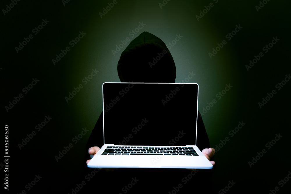 A laptop with a blank screen sits against a dark background, symbolizing the ominous nature of cyber threats. The image reflects themes of hacking, data breaches, and the importance of network securit
