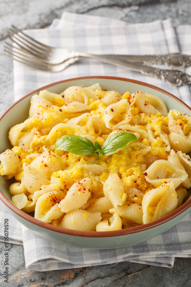 Conchiglie pasta with creamy corn cheese closeup in the bowl on the table. Vertical Conchiglie pasta with creamy corn cheese closeup in the bowl on the table. Vertical