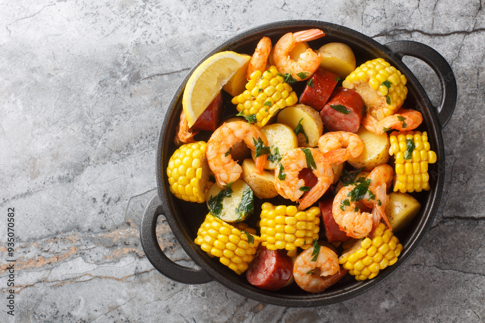 Homemade Cajun Seafood Boil with shrimp, corn, baby potatoes, sausage and lemons closeup on the table. Horizontal top view from above