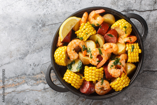 Obraz na płótnie Homemade Cajun Seafood Boil with shrimp, corn, baby potatoes, sausage and lemons closeup on the table. Horizontal top view from above w salonie