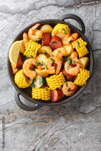 Traditional Cajun Shrimp Boil with Sausage Potato Corn and lemons closeup on the table. Vertical top view from above