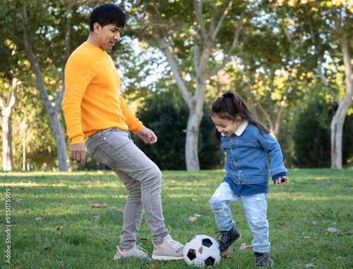 Dominican single father and son playing in a park with a football ball