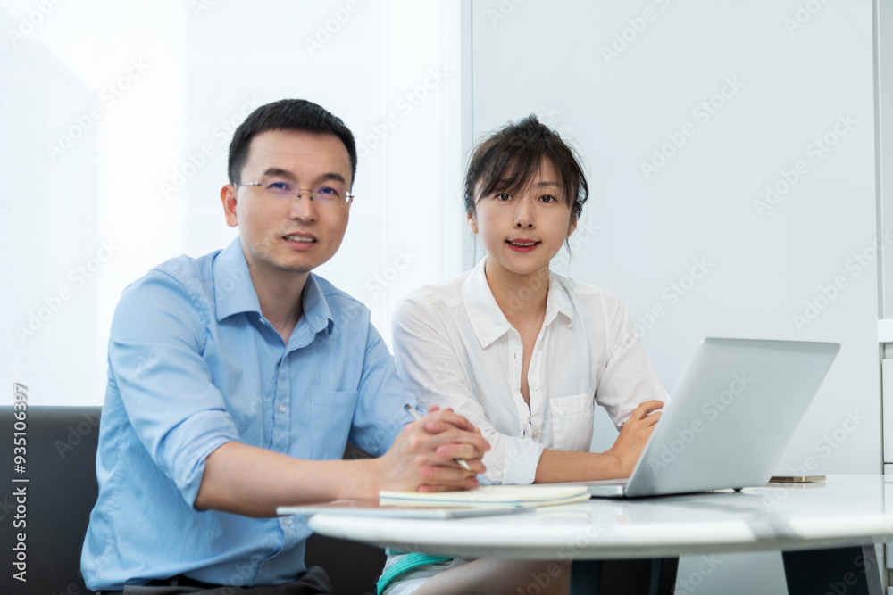 Two asian businesspeople working together in the office while using laptop Two asian businesspeople working together in the office while using laptop