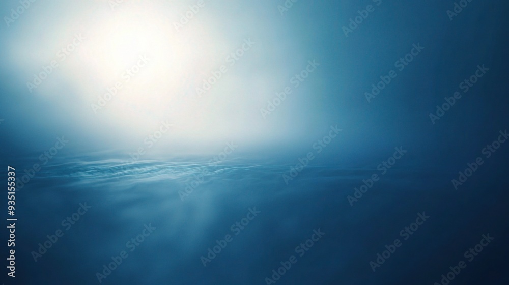 Obraz premium Celestial Dawn: ethereal glow of the rising sun illuminates a tranquil sea of clouds, casting a serene blue hue across the vast expanse. 