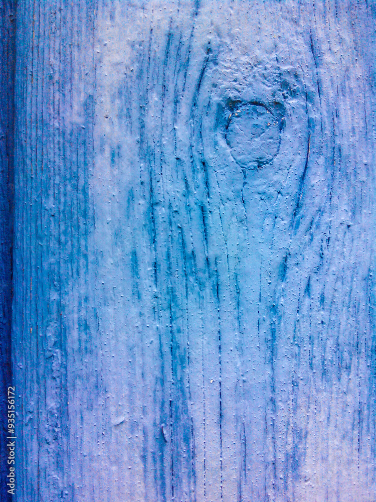 An old board with a knot painted with thick blue paint. The texture of the wood is visible An old board with a knot painted with thick blue paint. The texture of the wood is visible