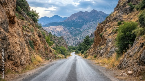 photo of a narrow asphalt road in a mountainous area.