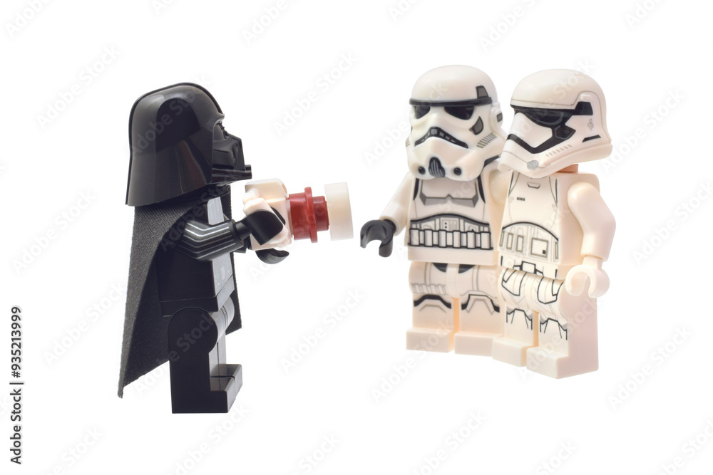 Fototapeta premium Lego minifigure of Darth Vader is taking a picture of two soldiers. Editorial illustrative image of popular children plastic bricks Star Wars. 