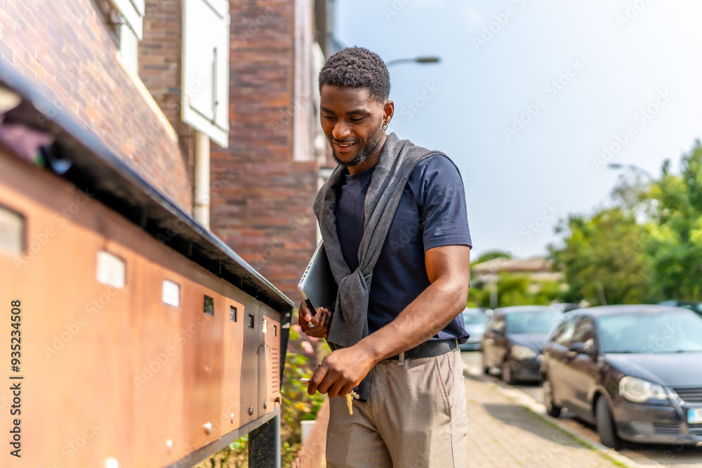 Young african businessman checking the mailbox on the street Young african businessman checking the mailbox on the street