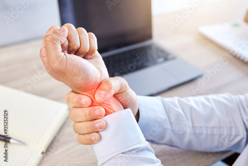 Arthritis, injury or wrist pain with business man at desk in office with laptop and glowing overlay. Accident, anatomy and burnout with red highlight on arm of employee in workplace for strain