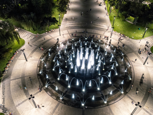 Aerial modern glowing circle fountain look down in night Freedom Square in Kharkiv city, Ukraine